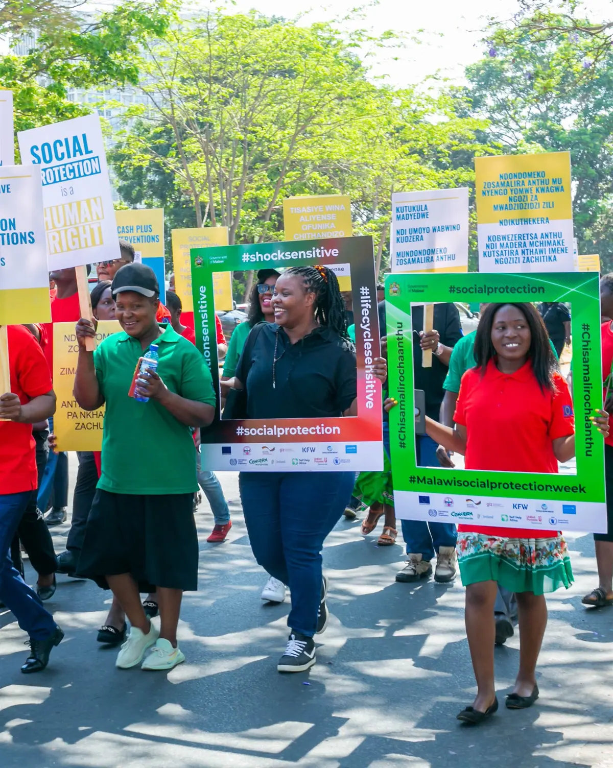 A march with 'Social Protection is a Human Right' placards